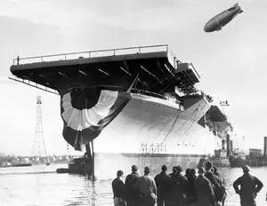 USS_Bunker_Hill_Launching_Fore_River_With_ZP-11_Blimp_Overhead_December_11_1942