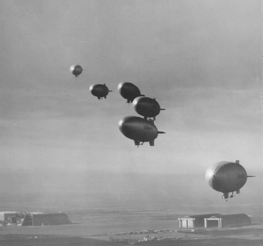Six U.S. Navt blimps flying over an LTA airfield